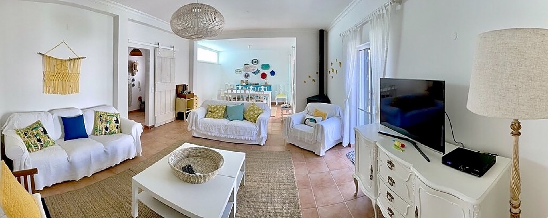 Spacious open-plan living room with slipcovered sofas and terracotta tiled floor